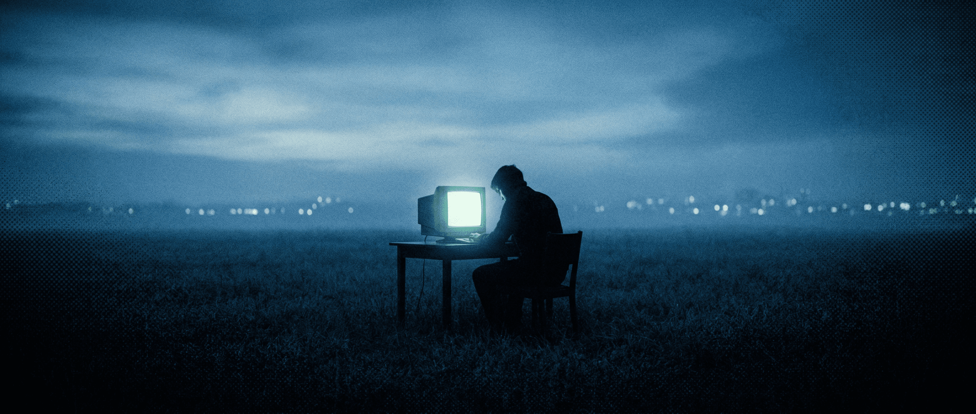A lone figure coding in an open field at night
